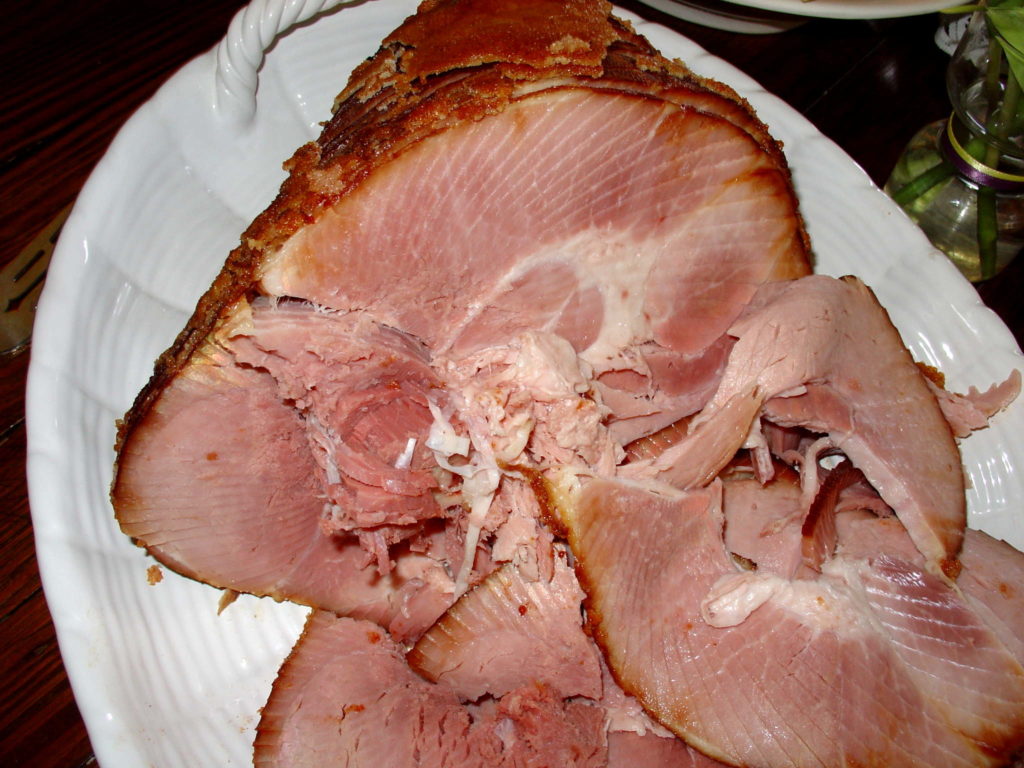 Carved baked ham around a bone