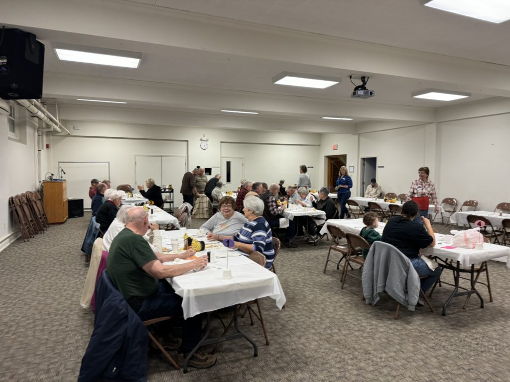 November 2023 Community Dinner-folks eating in fellowship hall.