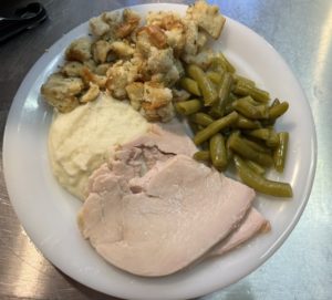 plate with roast turkey, stuffing, mashed potatoes, and green beans