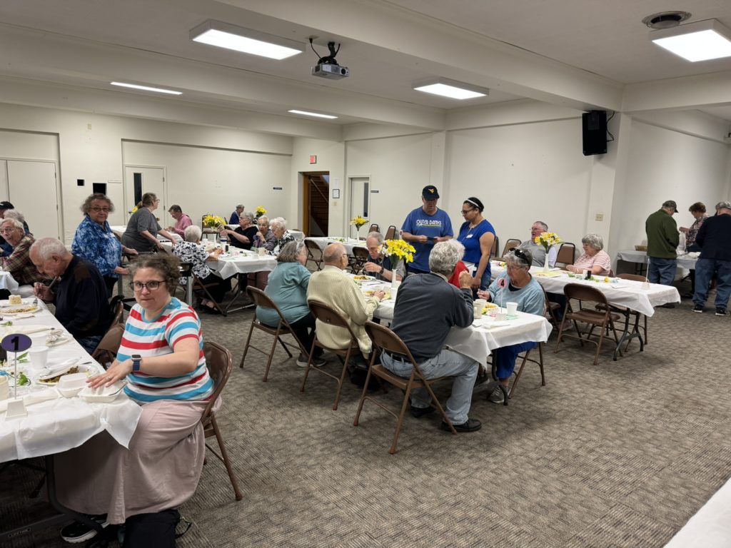 a picture of the April community dinner with diners fellowshipping and eating