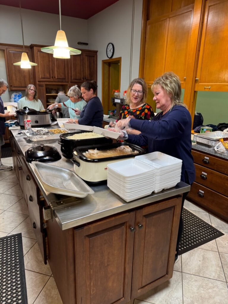 Workers plating food for October Community dinner.